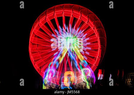 Verschwommene Riesenrad, Ferris mit Langzeitbelichtung Technik in der Nacht fotografiert. Bewegungsunschärfe Stockfoto