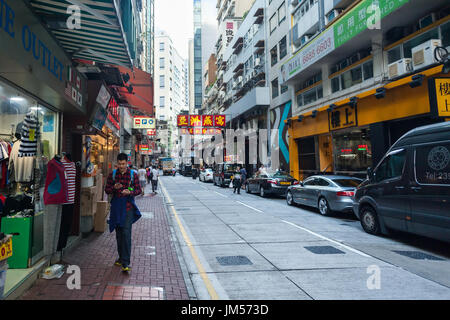 HONG KONG - 22. Oktober 2016: Schmale Gasse mit dem Verkehr zwischen hohen Gebäuden in Soho, Hong Kong Island. Stockfoto