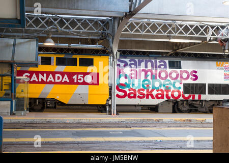 Mit dem Zug auf der Plattform an der Union Station in Toronto mit Kanada 150-Logo auf dem Zug. Reisen quer durch Kanada Stockfoto
