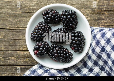 Leckere reife Brombeeren in Schüssel auf Holztisch. Stockfoto