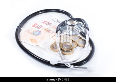 Schwarz Stethoskop Haufen von GBP Banknoten und Münzen isoliert wie Gesundheitswesen Kosten Konzept, close-up von oben betrachtet auf weißem Hintergrund Stockfoto