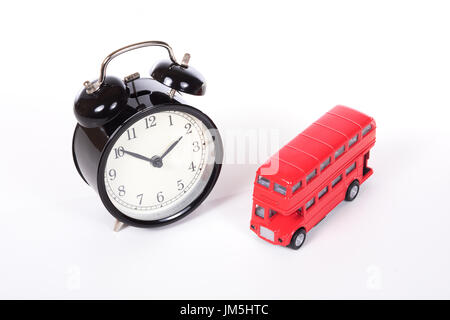 Klassische schwarze Wecker in der Nähe von roten Großbritannien Doppeldecker Bus Spielzeug aus hohen Blickwinkel betrachtet und isoliert auf weißem Hintergrund Stockfoto
