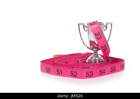 Maßband in Zoll aufgewickelt um kleine Silber Sport Cup markiert rot, Vorderansicht isolierten auf weißen Hintergrund mit Textfreiraum Stockfoto