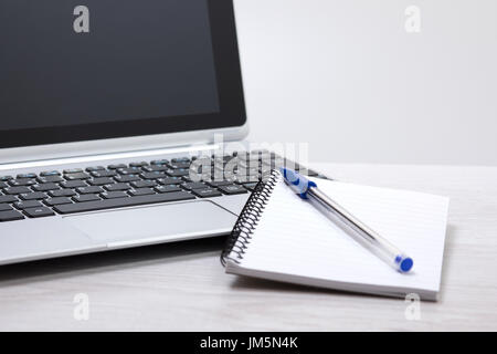 Online-Studie oder e-Learning-Konzepts mit einem leeren Notizblock und Kugelschreiber liegt auf einer offenen Laptop-Computer in einer niedrigen Winkel Ansicht mit Textfreiraum Stockfoto