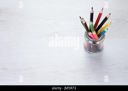 Glas-Glas, gefüllt mit Buntstift Buntstifte in Bildungs- oder Kunstkonzept mit textfreiraum neben von oben gesehen. Stockfoto