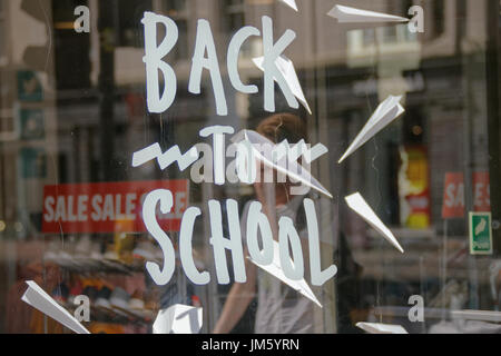 zurück zu Schule Verkauf Shop Fenster Papier Flugzeuge Reflexionen von Studenten Stockfoto