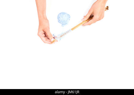 Weibes Hände und Stricknadeln mit blauen Knäuel auf weißem Hintergrund Stockfoto