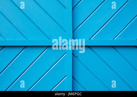 Eine blaue Holzwand mit Quadranten und diagonalen Muster. Stockfoto