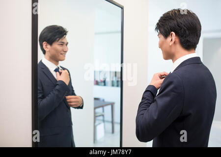 Junge chinesische Geschäftsmann Ankleiden am Morgen Stockfoto