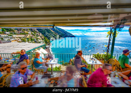 Fahren von einem Cliffside Restaurant mit Touristen Essen, wie sie die schöne Amalfi Küste und Hügel Stadt in Italien übersehen Stockfoto