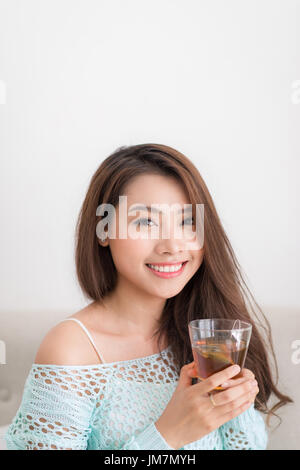 Schöne junge asiatische Frau trinken ihren Tee über ein Frühstück zu Hause. Stockfoto