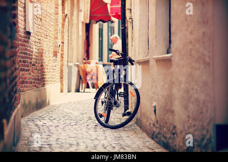 Ein Fahrrad auf der schmalen Straße in Amsterdam. Retro-street View von Amsterdam. Stockfoto