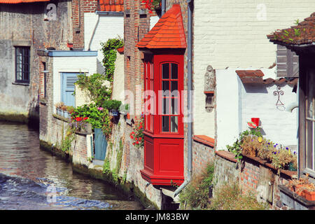 Blick auf den Fluss, alten Mauern von Brügge Gebäuden. Roten Erker über Wasserkanal in Brügge. Stockfoto