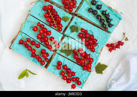 Blaue vegane Scheiben Käsekuchen mit Beeren. Liebe für eine gesunde vegane Ernährung Konzept. Stockfoto