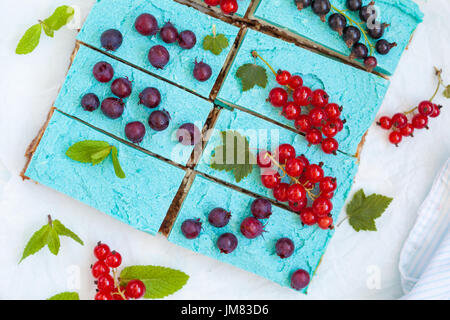 Blaue vegane Scheiben Käsekuchen mit Beeren. Liebe für eine gesunde vegane Ernährung Konzept. Stockfoto