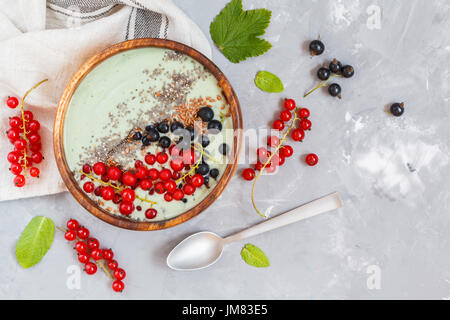 Spirulina-Smoothie-Schüssel mit Beeren und Chia. Liebe für eine gesunde vegane Ernährung Konzept. Stockfoto