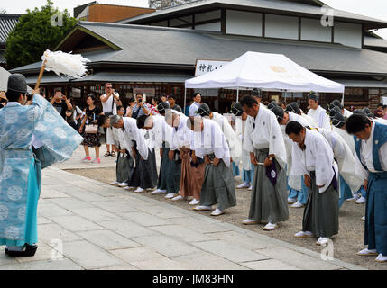 KYOTO, JAPAN - 24. Juli 2017: A Shinto-Priester segnet Männer tragen traditionellen Kleidung, wie sie für die Parade zum Gion Matsuri am Yasaka Jinja sammeln Stockfoto