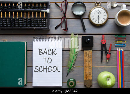 Zurück zur Schule handschriftlich auf einem Notizblock mit Schreibwaren Stockfoto