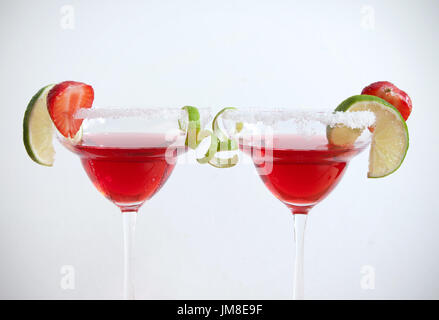 Zwei Cocktailgläser mit Kalk und Erdbeeren Scheiben auf einem weißen Hintergrund Stockfoto