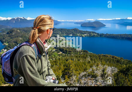 Frau sitzt auf der Sicht auf Berg Cerro Campanario, Argentinien und bewundern Sie die atemberaubende Aussicht auf den Lake District Stockfoto