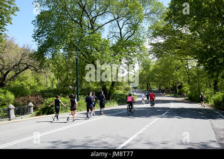 Menschen zu Fuß laufen und Radfahren entlang Ost fahren Central Park am Wochenende New York City USA Stockfoto