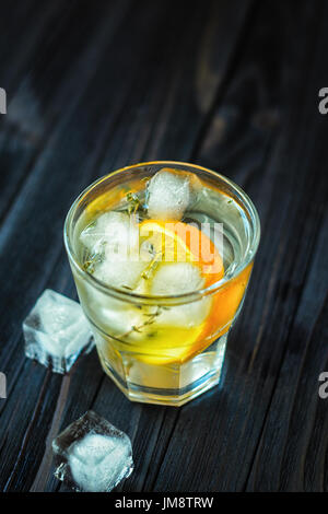 Kühlen cocktail mit Orange, Tonic, Wodka und Eis auf Holz dunkel Stockfoto