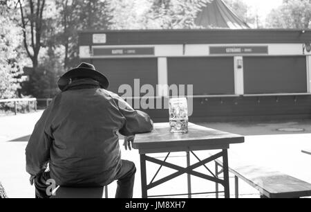 Mann genießt ein Bier im englischen Garten von München. Stockfoto