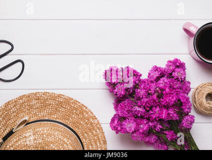 Hut, Blumen und Kaffee auf dem weißen Hintergrund Holz Stockfoto