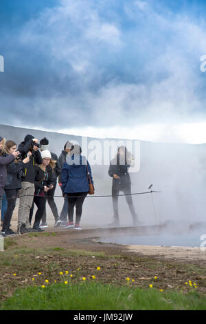 Touristen stehen in der Stokkur Geysir, Island erzeugte Dampf Stockfoto