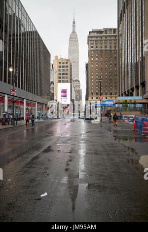 Reflexion der das Empire State building auf nassen Straßen im Regen New York City USA Stockfoto