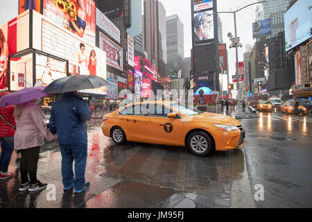 Toyota Camry Hybrid New York gelbes Taxi Cab überqueren Times Square in New York City USA Regen Stockfoto