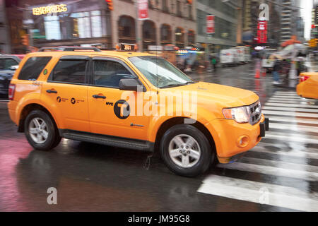 Ford Escape Hybrid Suv New York gelbes Taxi Cab überqueren Times Square in New York City USA Regen Stockfoto