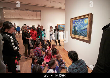 Schulgruppe auf Tour sitzen und Blick auf Vincent van Goghs Sternennacht Moma New York City USA Stockfoto