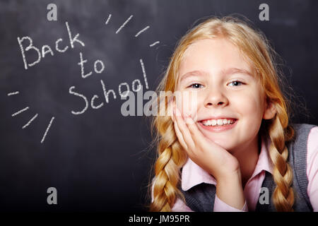 Schulkind auf Tafel Hintergrund Stockfoto