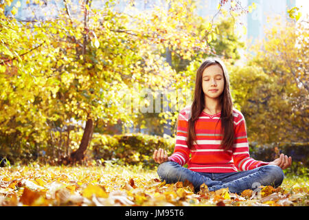 Teenager-Mädchen meditieren im Herbst park Stockfoto