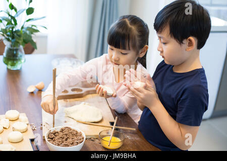 Happy Chinese Geschwister gemeinsam Backen Stockfoto