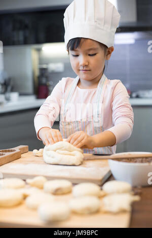 Glückliche kleine Chinesin Backen zu Hause Stockfoto