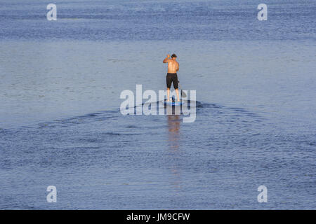 Mann auf Paddle Board paddeln, zum See Stockfoto