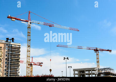 Frontansicht der vier Turmdrehkrane auf einer Baustelle mit blauem Himmel. Stockfoto