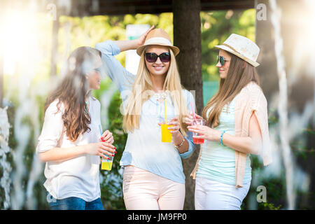 Freundinnen genießen Cocktails von einem Brunnen, Freundschaft-Konzept Stockfoto