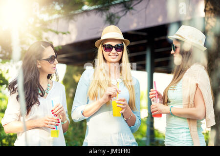 Freundinnen genießen Cocktails von einem Brunnen, Freundschaft-Konzept Stockfoto