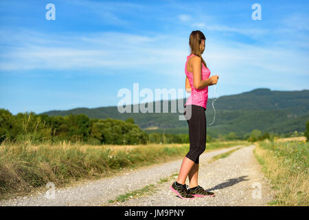 Attraktive weibliche Läufer mit Kopfhörer, bereit für ihr Training Stockfoto