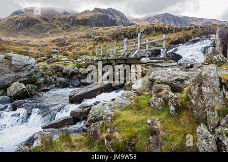 Brücke über den Wasserfall in der Nähe von Llyn Ogwen auf dem Weg zur Llyn Idwal und des Teufels Küche im Glyderau-Gebirge Snowdonia North Wales UK Febr Stockfoto