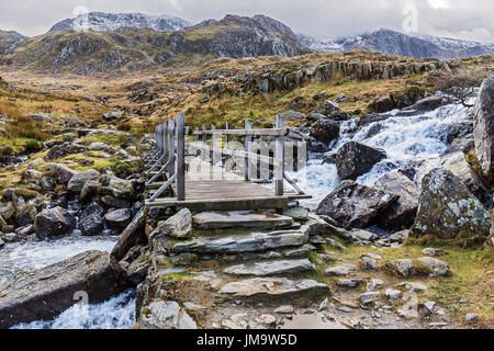 Brücke über den Wasserfall in der Nähe von Llyn Ogwen auf dem Weg zur Llyn Idwal und des Teufels Küche im Glyderau-Gebirge Snowdonia North Wales UK Febr Stockfoto