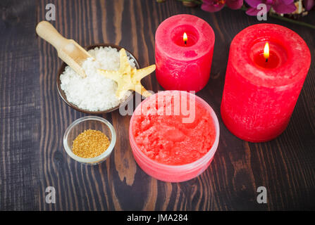 Kerzen und Satz von Elementen für die Körperpflege auf einem hölzernen Hintergrund. Das Konzept der Entspannung und Wellness. Stockfoto