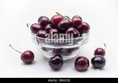 Glasvase mit nassen Kirsche Beeren isolierten auf weißen Hintergrund Stockfoto