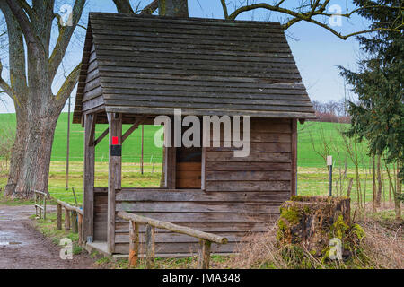 Alte Holzhütte zum Schutz vor Wind, Regen oder Schnee an einem Teich in der Nähe der Stadt Heiligenhaus in Deutschland. Stockfoto