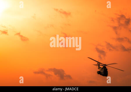 Hubschrauber auf Airshow. Kunstflug-Team führt Flug bei Flugschau. Flug in der Dämmerung. Stockfoto