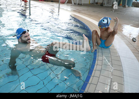 Sarajevo, Bosnien und Herzegowina. 25. Juli 2017. Behinderte junge spielt Ismail Zulfic (R) mit seinem Trainer in einem Schwimmbad in Sarajevo, Bosnien und Herzegowina, 25. Juli 2017. Ismail Zulfic begann, vor 18 Monaten schwimmen zu lernen. Er musste ganz von Zenica nach Sarajevo (70 km voneinander entfernt) zweimal in der Woche gehen die neue Fertigkeit erlernen. Bildnachweis: Haris Memija/Xinhua/Alamy Live-Nachrichten Stockfoto