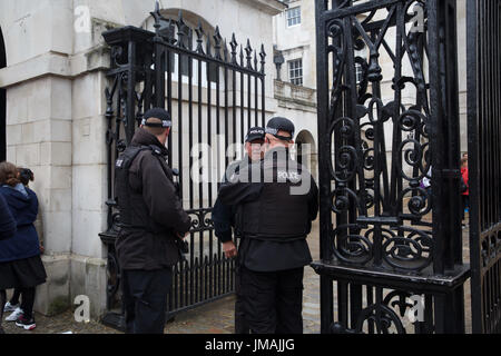 London, UK. 26. Juli 2017. Die typisch britische nasse und düstere Wetter nicht davon abhalten, Besucher und Touristen nach London. Polizei stehen außen Horseguards Parade in Whitehall Credit: Keith Larby/Alamy Live News Stockfoto